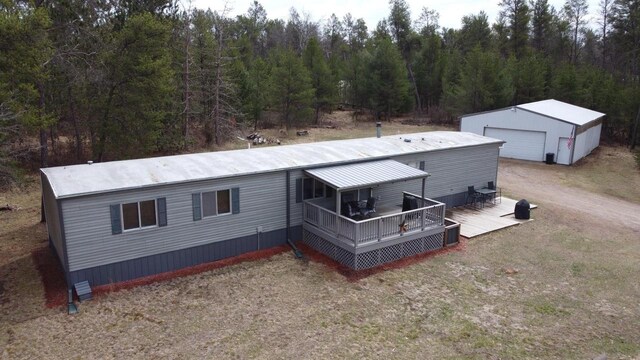 N9140 Snow Snake Trl, Necedah, WI 54646 - exterior space featuring a wooded view, a wooden deck, an outbuilding, and a detached garage