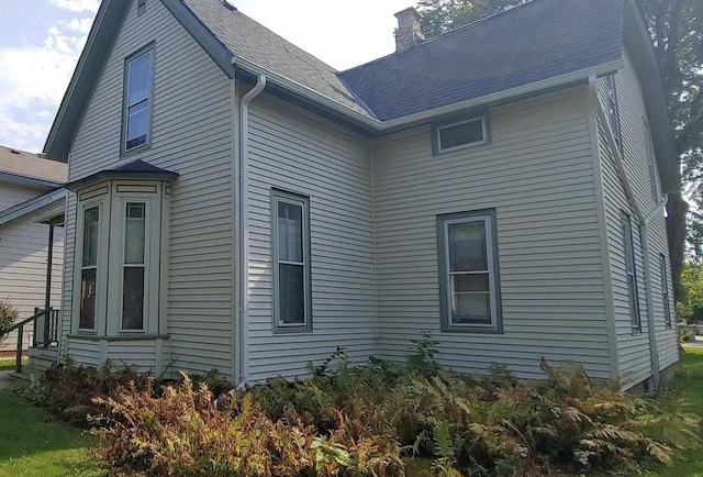 3313 W Kilbourn Ave, Milwaukee, WI 53208 - view of side of property featuring a shingled roof and a chimney