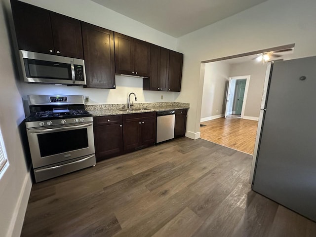 3313 W Kilbourn Ave, Milwaukee, WI 53208 - kitchen featuring dark brown cabinets, dark wood-style floors, a sink, and appliances with stainless steel finishes