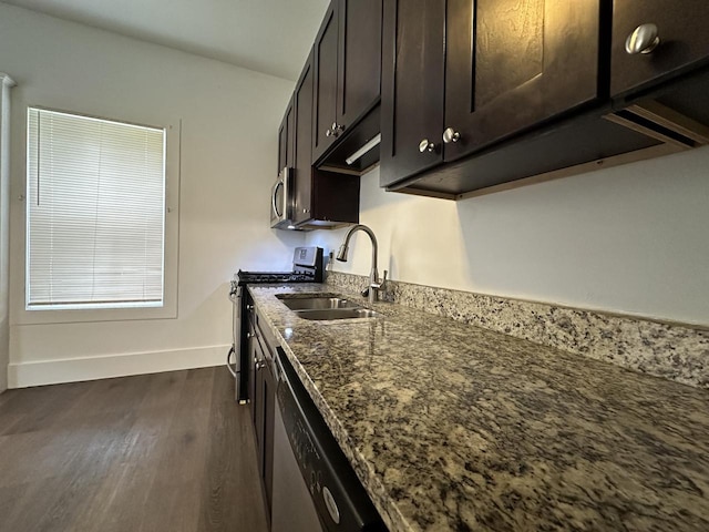 3313 W Kilbourn Ave, Milwaukee, WI 53208 - kitchen with dark stone countertops, dark brown cabinets, a sink, appliances with stainless steel finishes, and dark wood-style flooring