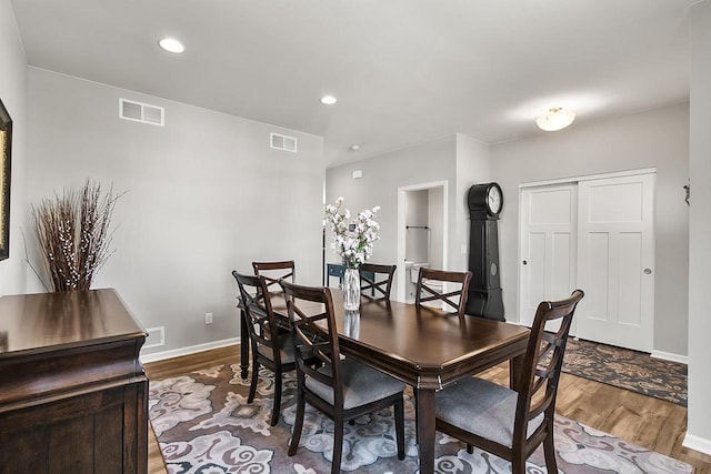 dining space featuring wood finished floors, visible vents, and baseboards