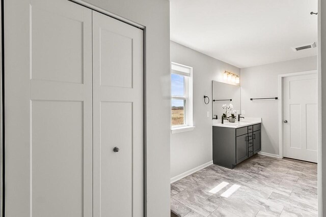 bathroom with marble finish floor, baseboards, vanity, and visible vents