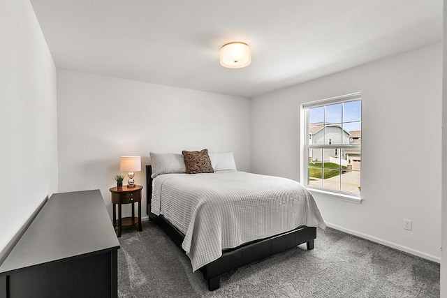 bedroom with baseboards and dark carpet