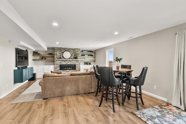 dining area with light wood finished floors, baseboards, a fireplace, and recessed lighting