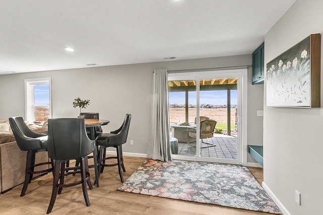 dining room featuring baseboards, a healthy amount of sunlight, light wood-style floors, and recessed lighting