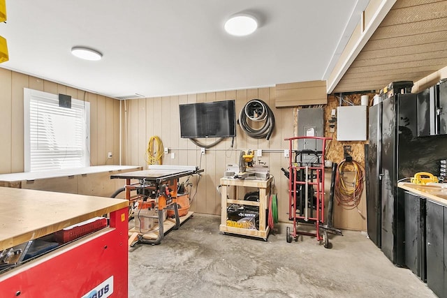 kitchen featuring concrete floors and wood walls
