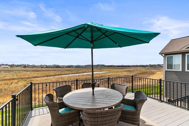 wooden deck featuring outdoor dining space and a rural view