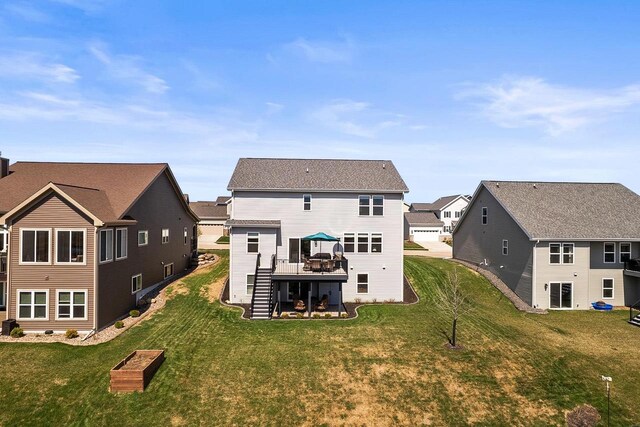 back of property featuring stairway, a yard, a residential view, and a deck