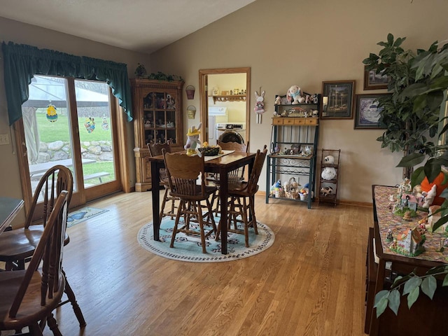 W360S10139 Markham Rd, Eagle, WI 53119 - dining space with washer / dryer, lofted ceiling, light wood-style floors, and baseboards