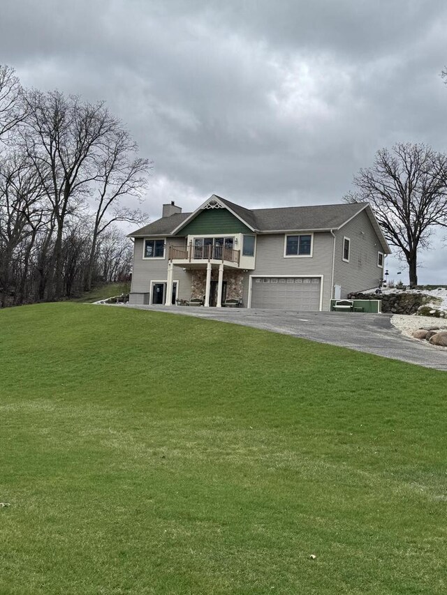 W360S10139 Markham Rd, Eagle, WI 53119 - view of front of property featuring a garage, a balcony, a front yard, and aphalt driveway