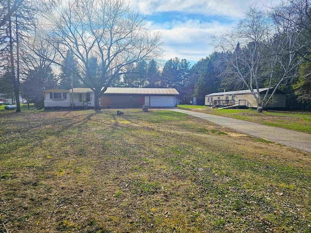 view of front of property with concrete driveway, a front lawn, and a garage