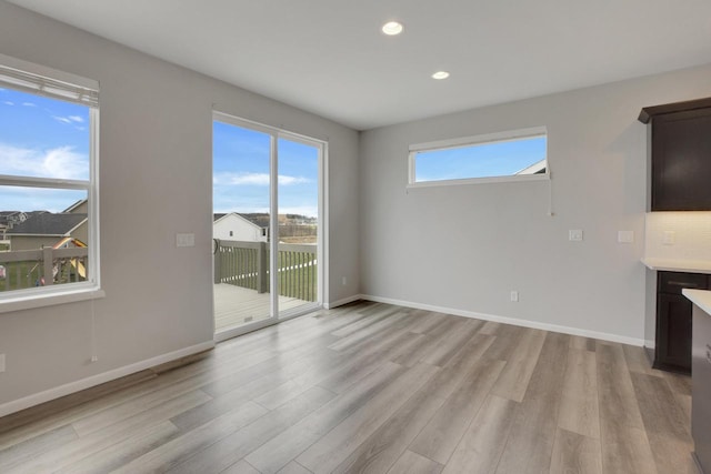 unfurnished living room featuring baseboards, light wood-style floors, and recessed lighting