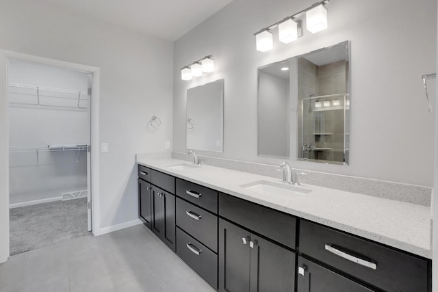 full bathroom with a shower stall, double vanity, visible vents, a sink, and a walk in closet