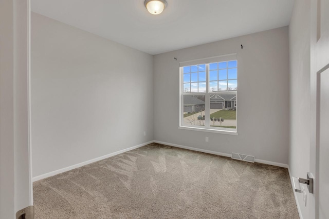 carpeted spare room featuring baseboards and visible vents