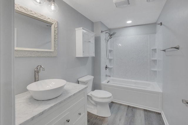 bathroom featuring wood finished floors, vanity, bathtub / shower combination, toilet, and visible vents