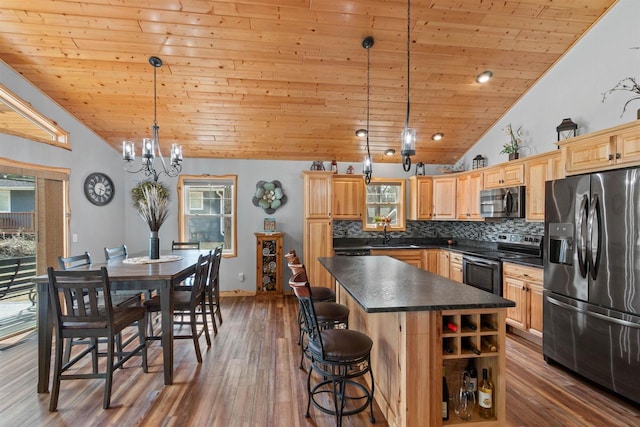 905 Plymouth Ct, Nekoosa, WI 54457 - kitchen with wood ceiling, vaulted ceiling, dark countertops, and stainless steel appliances