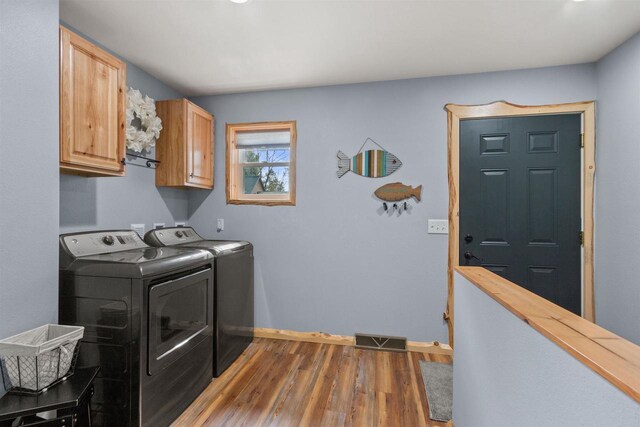 905 Plymouth Ct, Nekoosa, WI 54457 - washroom featuring wood finished floors, visible vents, independent washer and dryer, baseboards, and cabinet space