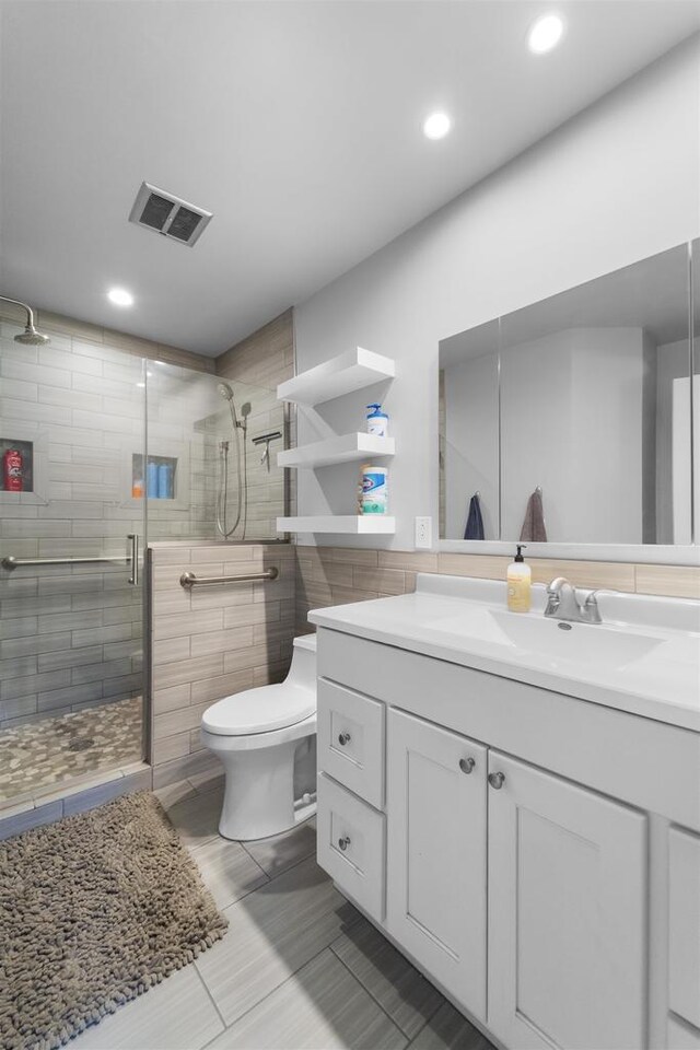 bathroom with visible vents, vanity, toilet, recessed lighting, and a shower stall