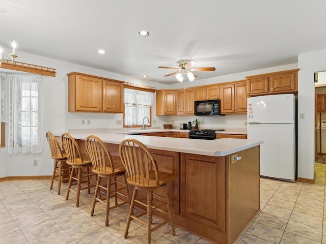 W7436 County Road V, Cascade, WI 53011 - kitchen with light countertops, brown cabinets, black appliances, and a ceiling fan