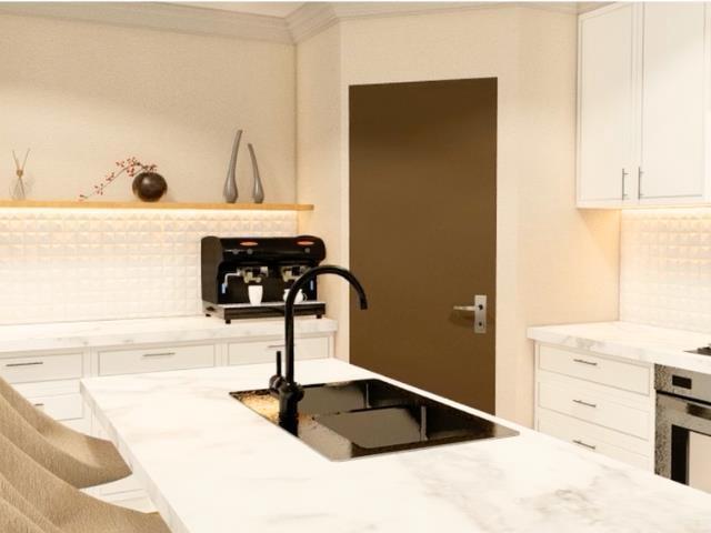 kitchen with stainless steel oven, backsplash, white cabinetry, and a sink