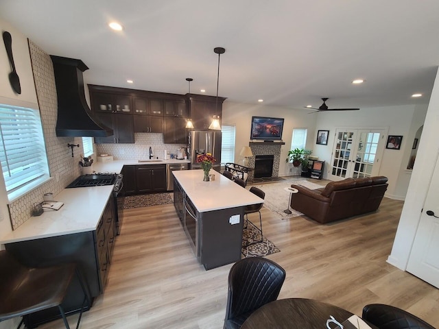 2034 N 13th St, Milwaukee, WI 53205 - kitchen featuring a fireplace with flush hearth, light countertops, custom exhaust hood, and appliances with stainless steel finishes