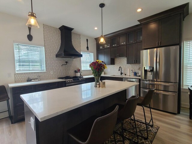 2034 N 13th St, Milwaukee, WI 53205 - kitchen featuring a sink, premium range hood, light wood-type flooring, decorative backsplash, and appliances with stainless steel finishes