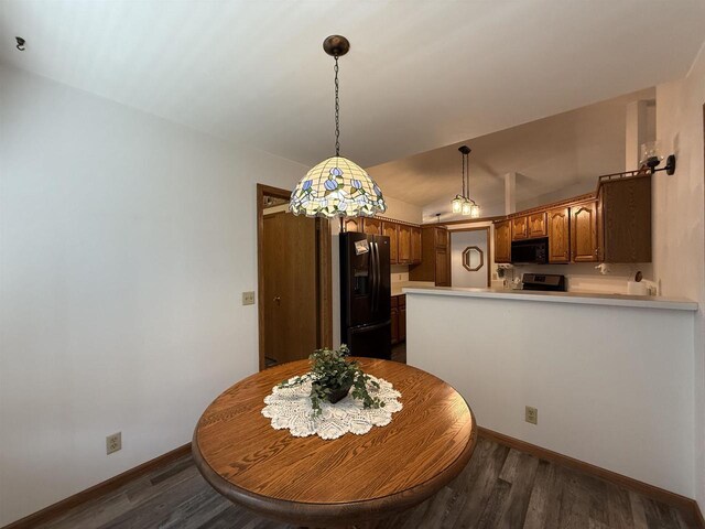 dining space featuring dark wood-type flooring, baseboards, and lofted ceiling