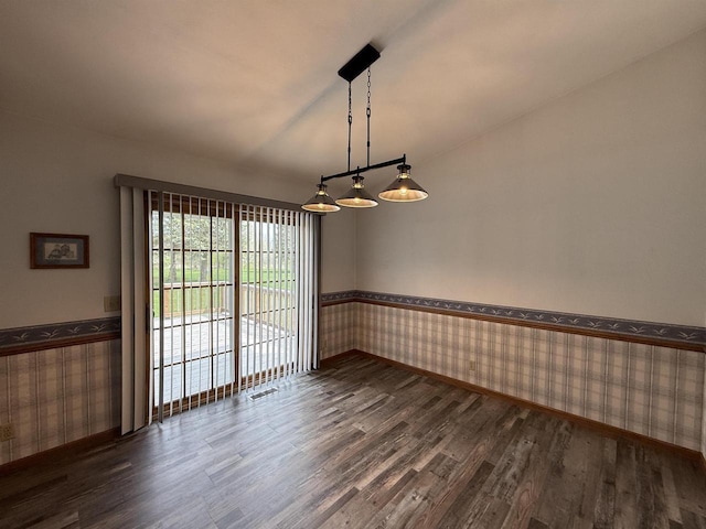 spare room with wallpapered walls, wainscoting, baseboards, and dark wood-type flooring
