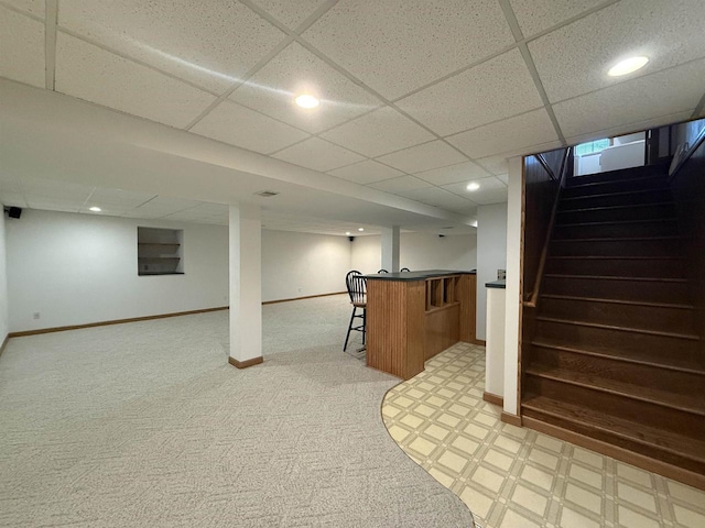 bar featuring stairs, baseboards, recessed lighting, light colored carpet, and bar