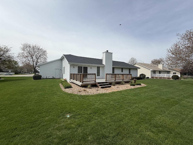 rear view of house with a chimney, a yard, and a deck
