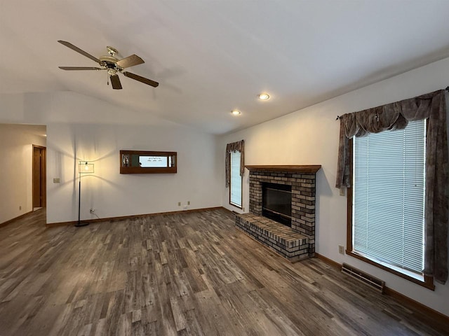 unfurnished living room with visible vents, wood finished floors, vaulted ceiling, and a fireplace