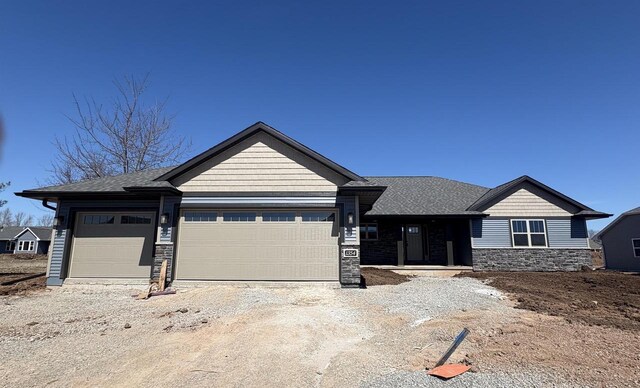 1354 Shelby Ln, De Pere, WI 54115 - view of front of property featuring roof with shingles, driveway, stone siding, and a garage
