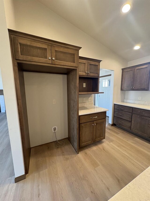 1354 Shelby Ln, De Pere, WI 54115 - kitchen with light wood-style flooring, dark brown cabinetry, recessed lighting, lofted ceiling, and light countertops