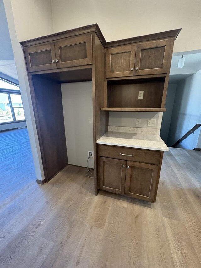 1354 Shelby Ln, De Pere, WI 54115 - kitchen with dark brown cabinets, light wood-style flooring, light countertops, and open shelves