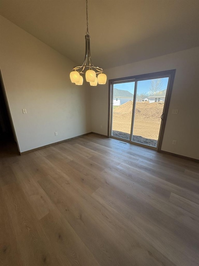 1354 Shelby Ln, De Pere, WI 54115 - spare room featuring baseboards, wood finished floors, and a chandelier