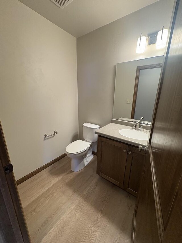 1354 Shelby Ln, De Pere, WI 54115 - half bath featuring toilet, visible vents, baseboards, wood finished floors, and vanity