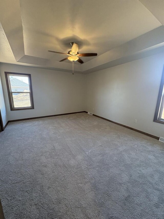 1354 Shelby Ln, De Pere, WI 54115 - spare room featuring a raised ceiling, visible vents, a ceiling fan, carpet floors, and baseboards
