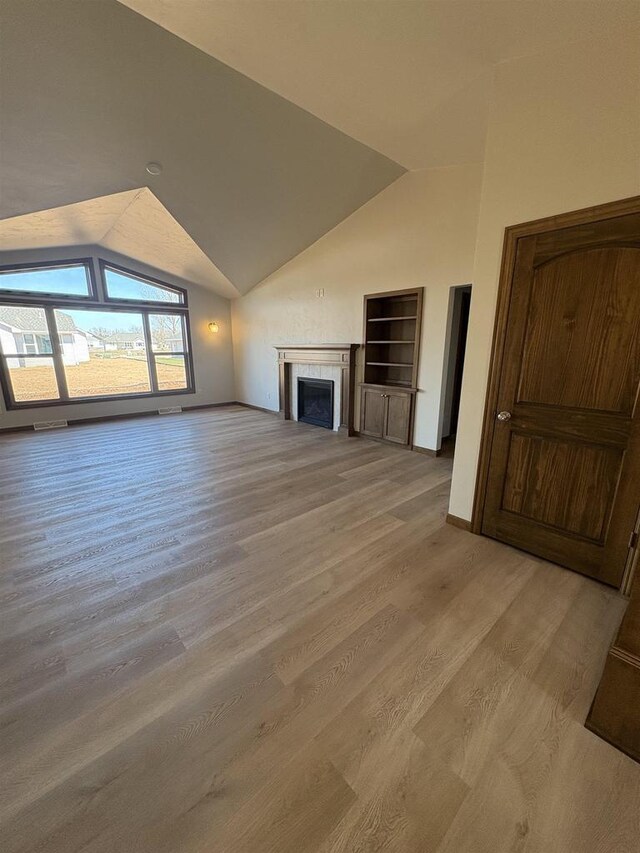 1354 Shelby Ln, De Pere, WI 54115 - unfurnished living room featuring baseboards, lofted ceiling, light wood-style floors, and a fireplace