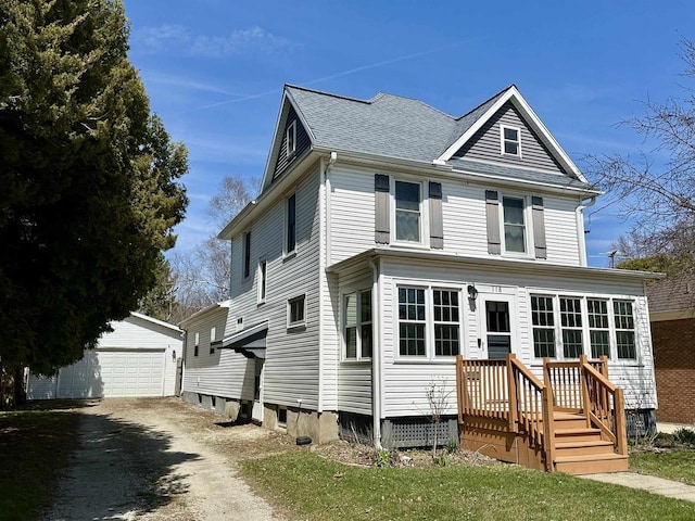 traditional style home with a garage, an outbuilding, and a shingled roof