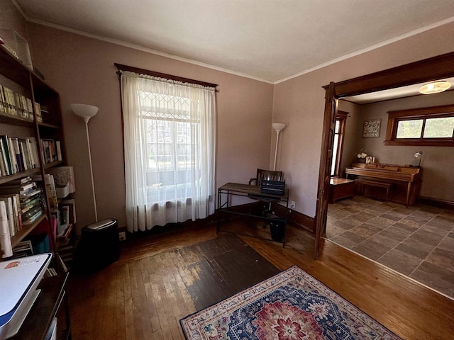 interior space featuring baseboards, ornamental molding, and wood-type flooring