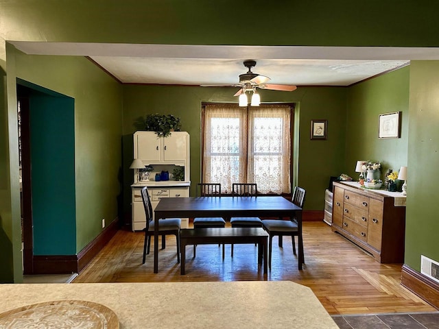 dining room featuring baseboards, ceiling fan, and wood finished floors