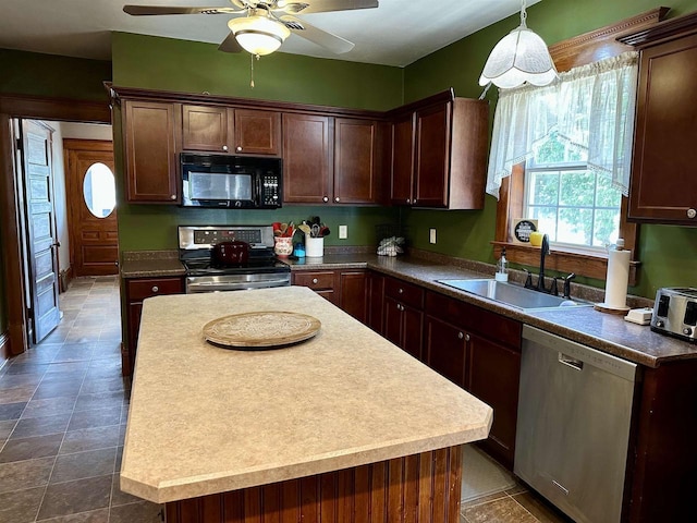 kitchen featuring dark brown cabinets, a sink, a center island, stainless steel appliances, and a ceiling fan