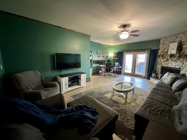 living area with ceiling fan, a fireplace, french doors, and wood finished floors
