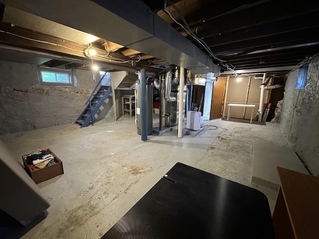 basement featuring stairs and water heater