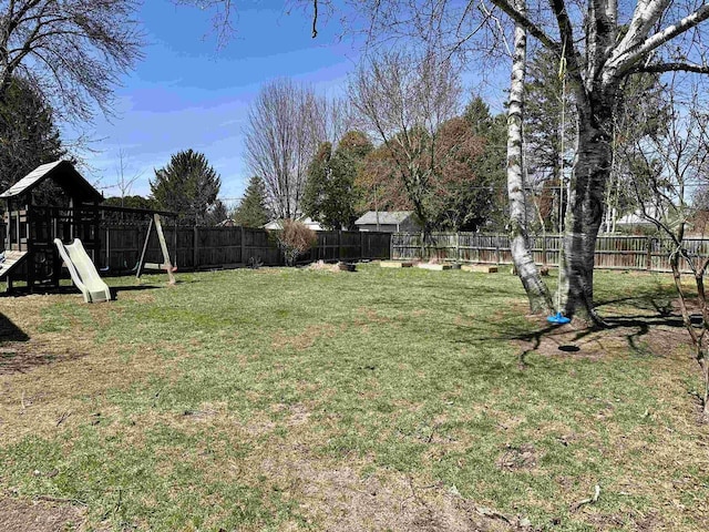view of yard featuring a fenced backyard and a playground