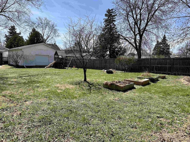 view of yard featuring a fenced backyard, a playground, an outbuilding, and a garden