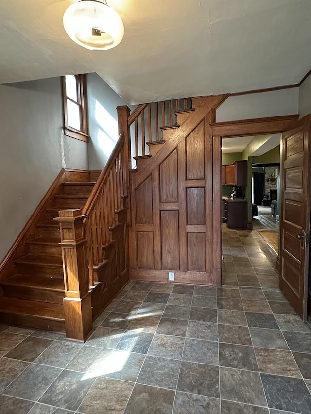 staircase featuring baseboards and stone finish flooring