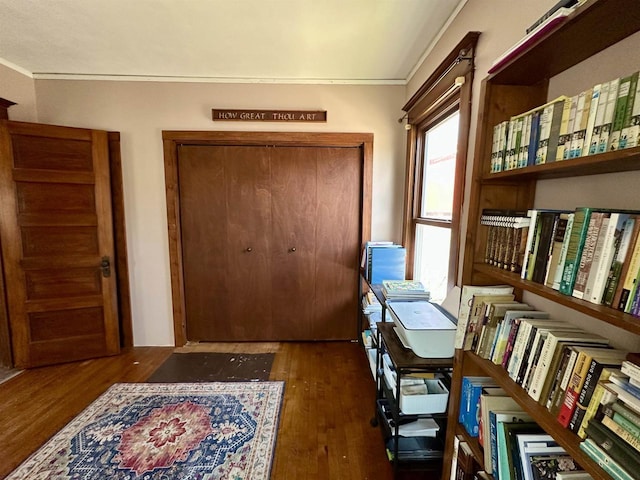 interior space with ornamental molding and wood finished floors