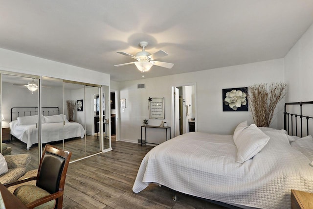 bedroom featuring ceiling fan, visible vents, dark wood-style floors, and a closet