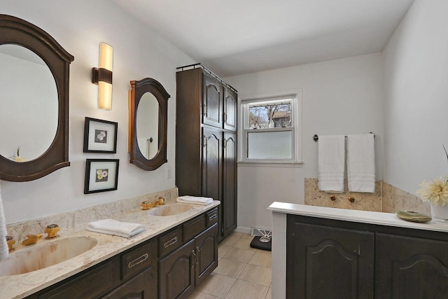 full bath featuring double vanity, tile patterned floors, and a sink